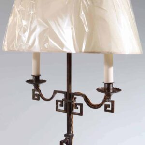 A patinated Steel floor standing bouillotte lamp with two branch shades and key scroll base, circa 1920, height 139 cm.