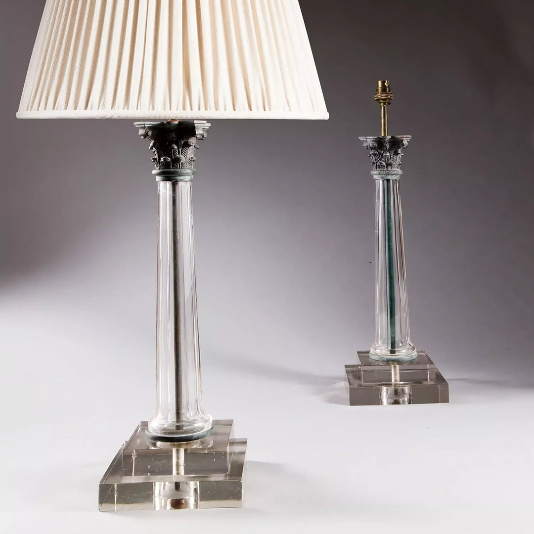 Pair of Clear Glass Faceted Column Lamps with bronze Corinthian capitals on stepped square bases, 20th century design.