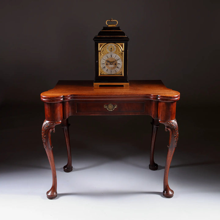 Mid 18th century ebony and gilt bronze bracket clock by John Ellicott displayed on antique wooden table Nwtiques
