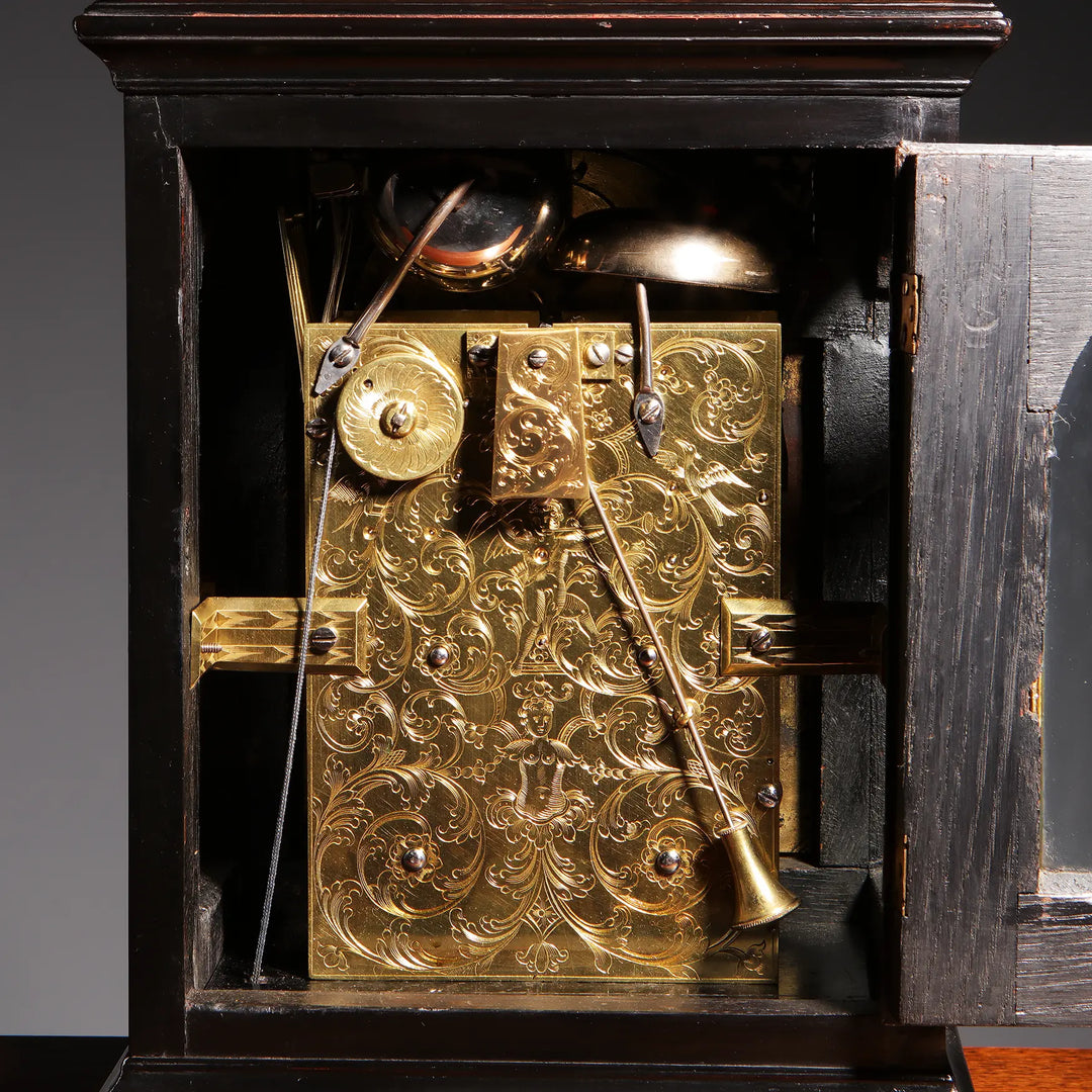 Intricately engraved gilt bronze clock mechanism inside ebony case from John Ellicott, offered by Nwtiques