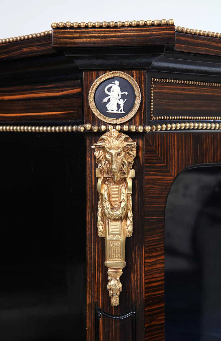 Ornate ormolu lion head detail and porcelain medallion on Nwtiques calamander wood cabinet