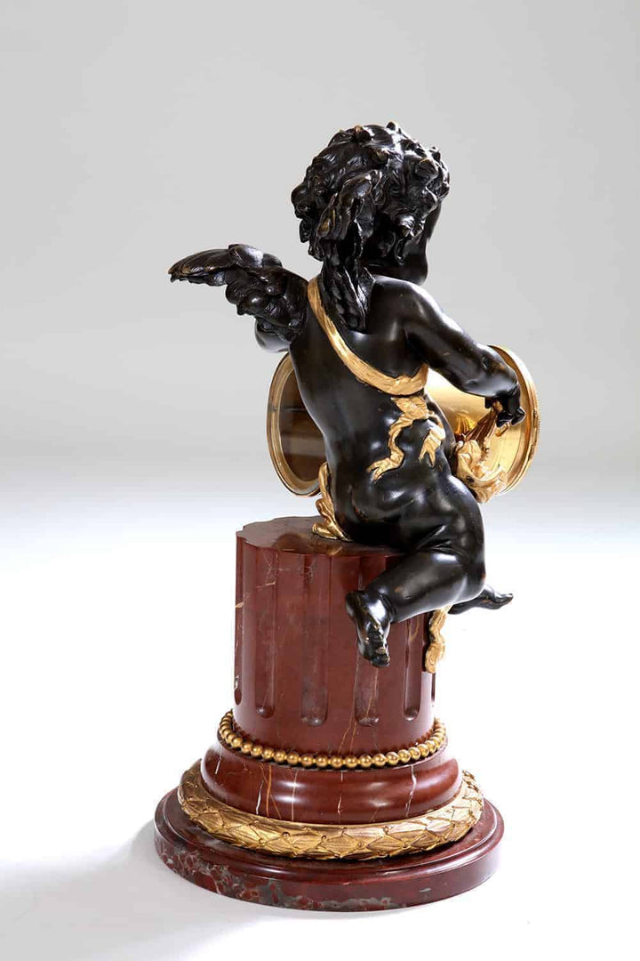 Gilt bronze cherub with ormolu details seated on rouge marble base from Nwtiques collection