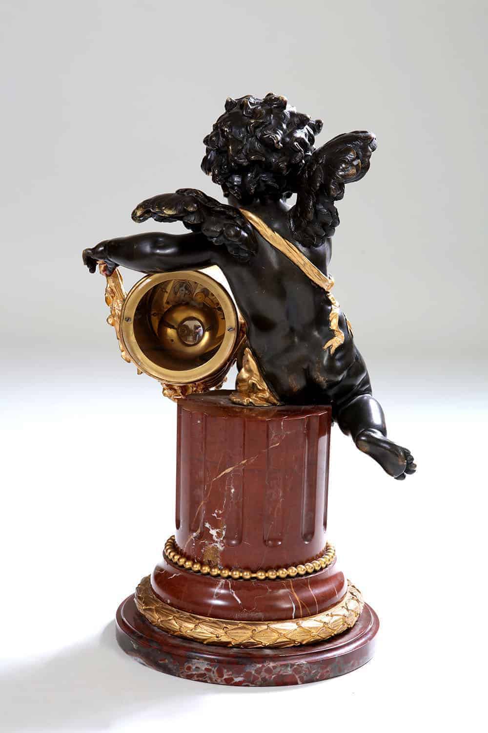 Back view of gilt bronze cherub clock on rouge marble column by Nwtiques circa 1870