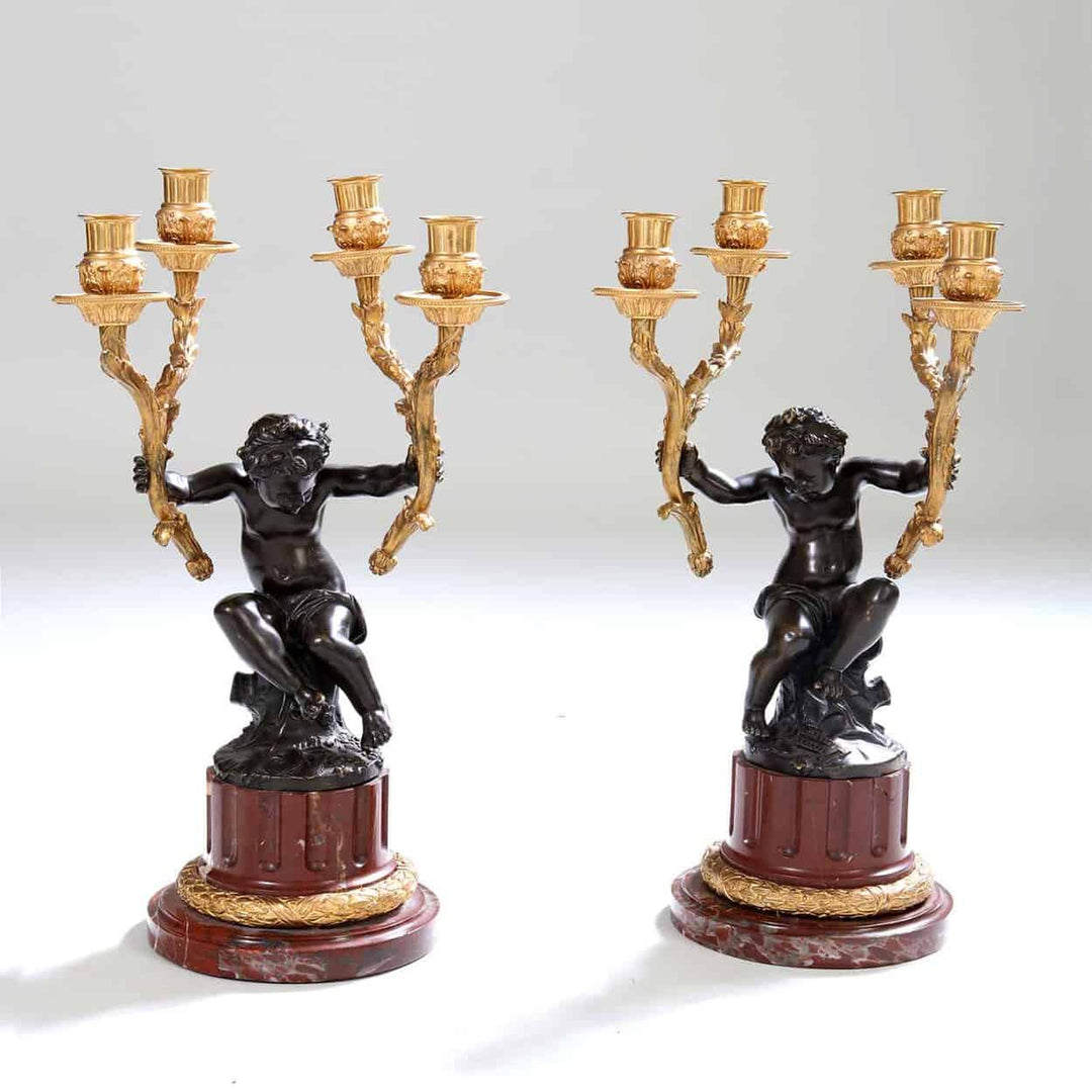 Pair of gilt bronze and marble candelabra with cherub figures by Nwtiques, 19th century French style