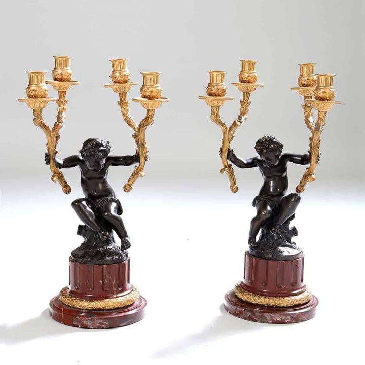 Pair of gilt bronze and marble candelabra with cherub figures by Nwtiques, 19th century French style