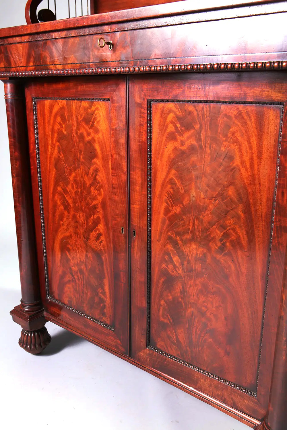 Early 19th century Regency mahogany chiffonier with flame wood panels and gadrooned bun feet by Nwtiques
