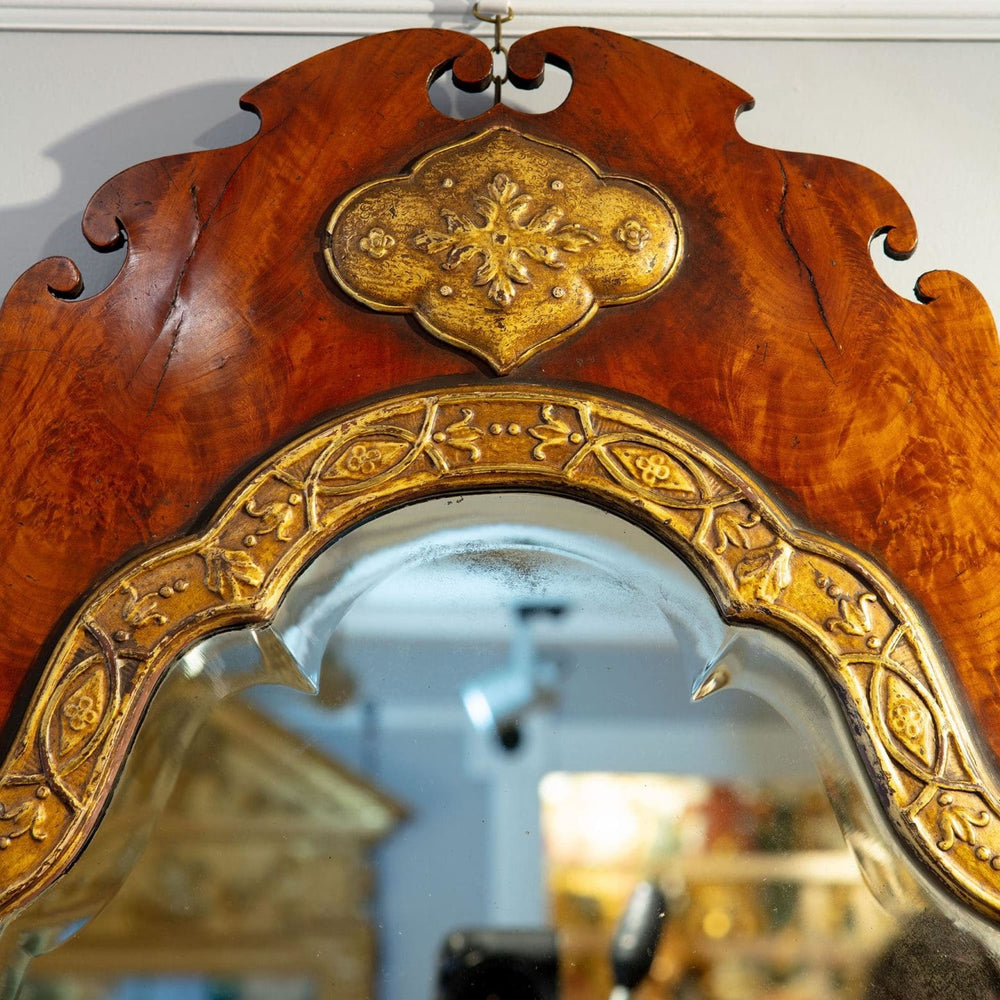 A George III flame veneered mahogany wall mirror with shaped fret cut frame and gilt gesso slip moulding.