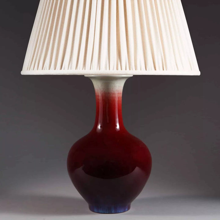 Chinese Sang de Boeuf Vase mounted as a table lamp with a red glaze, cream pleated shade, circa 1980, 27 cm height.