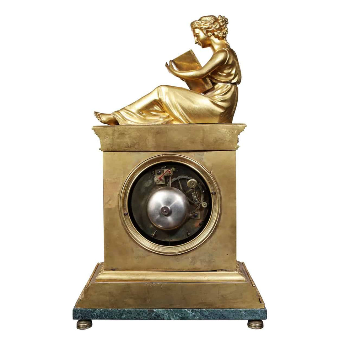 Early 19th-century fire gilt French mantle clock by Dautel featuring a reading figure, sold by Nwtiques.
