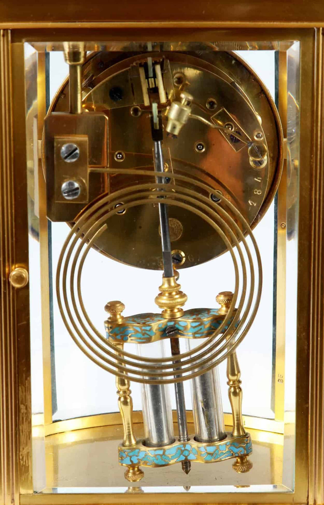 Close-up of the champleve enamel mercury pendulum inside an 8 day French carriage clock by Nwtiques