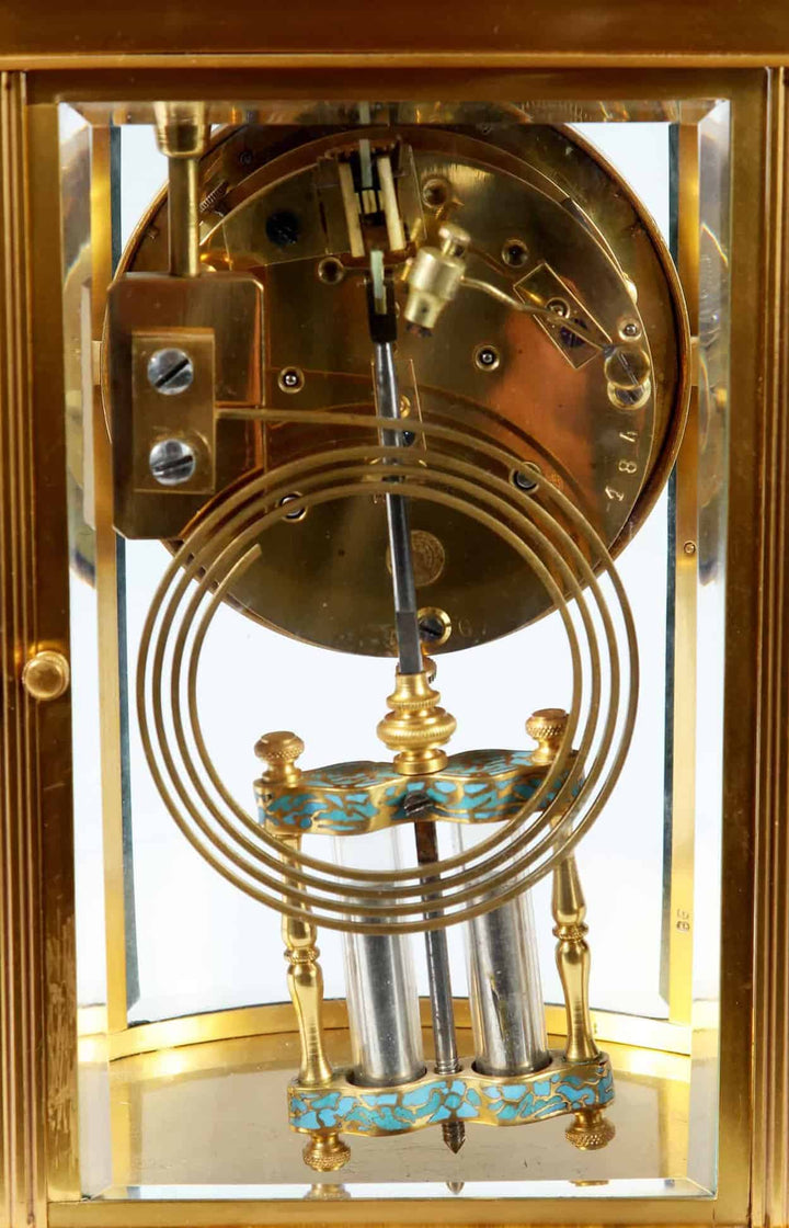Close-up of the champleve enamel mercury pendulum inside an 8 day French carriage clock by Nwtiques