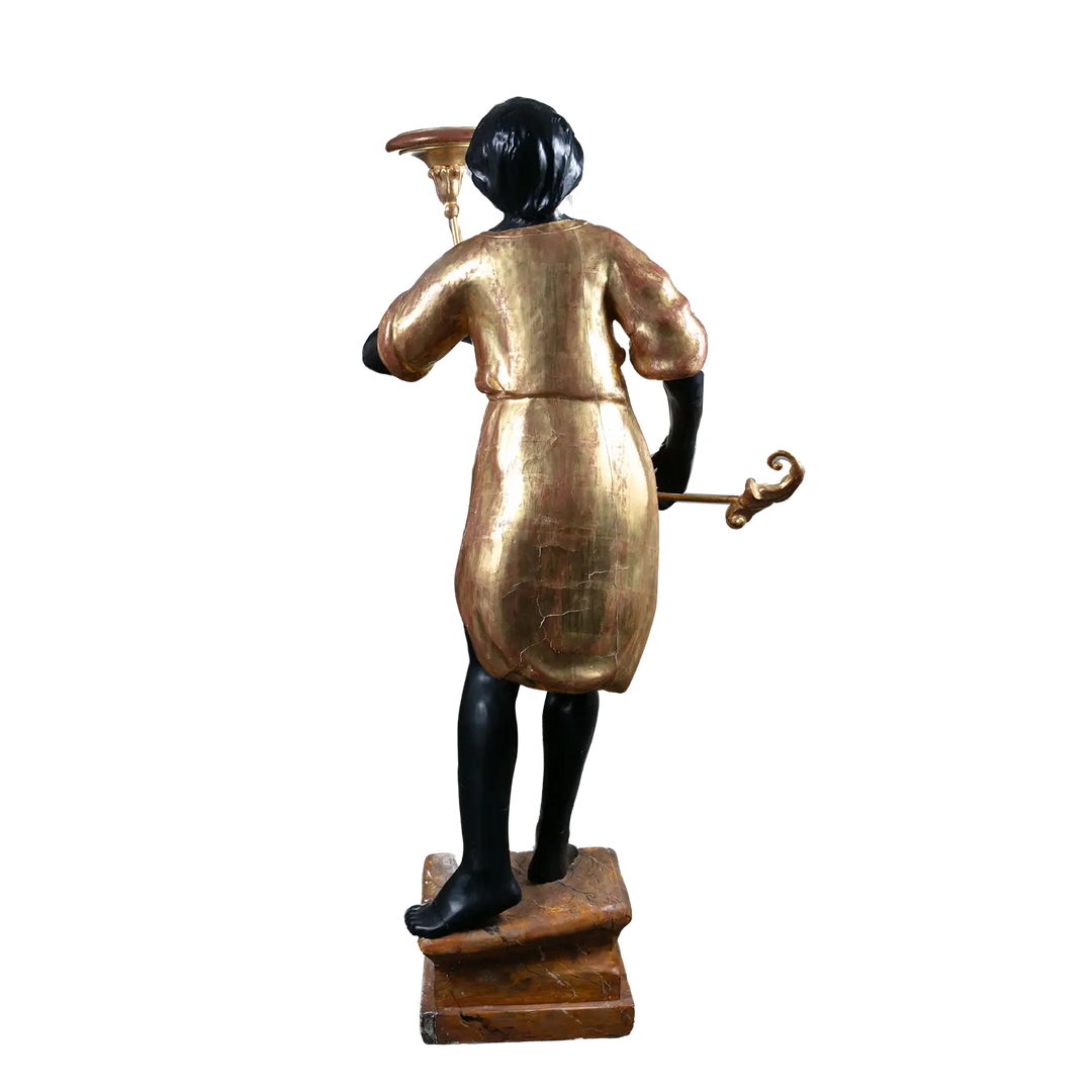 19th century Italian Blackamoor figure in giltwood by Nwtiques, standing on painted plinth holding torchere
