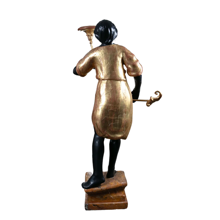 19th century Italian Blackamoor figure in giltwood by Nwtiques, standing on painted plinth holding torchere