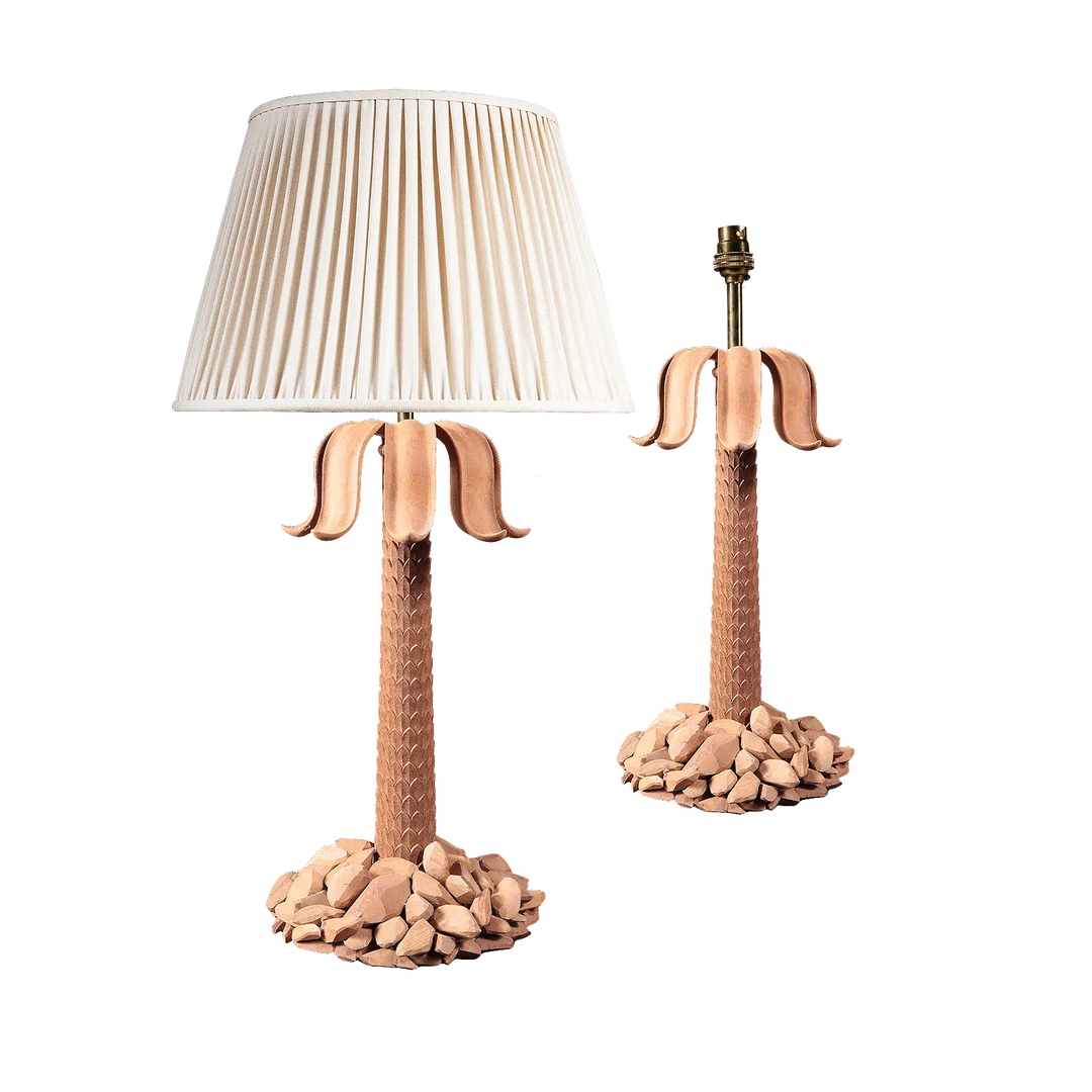 Pair of Palm Tree Table Lamps with carved rocky bases, imbricated stems, and sweeping petal leaves, one with shade.