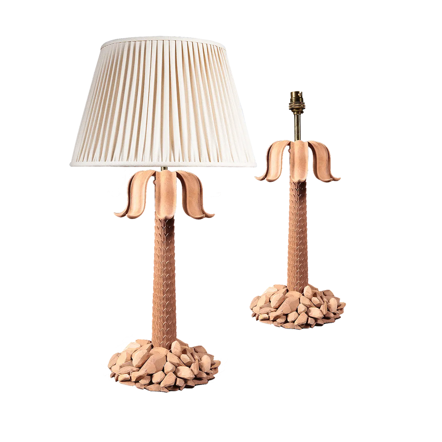 Pair of Palm Tree Table Lamps with carved rocky bases, imbricated stems, and sweeping petal leaves, one with shade.