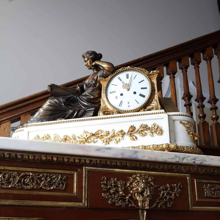 Late 19th-century French white marble mantel clock with gilt bronze by Nwtiques on ornate wooden surface
