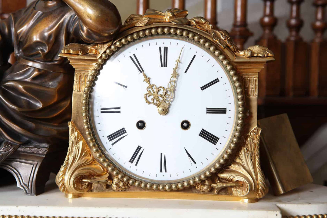 Late 19th-century French mantel clock by Nwtiques with gilt bronze case and white enamel dial.