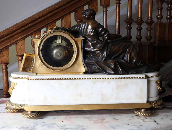 A fine French Neo Classical mantel clock by Nwtiques with marble base and bronze figure detail.