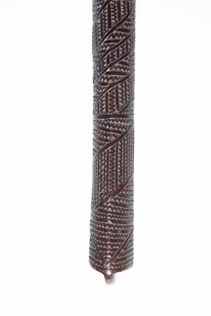 Close-up of an intricately carved Tongan ironwood war club handle by Collection ON10 with traditional patterns