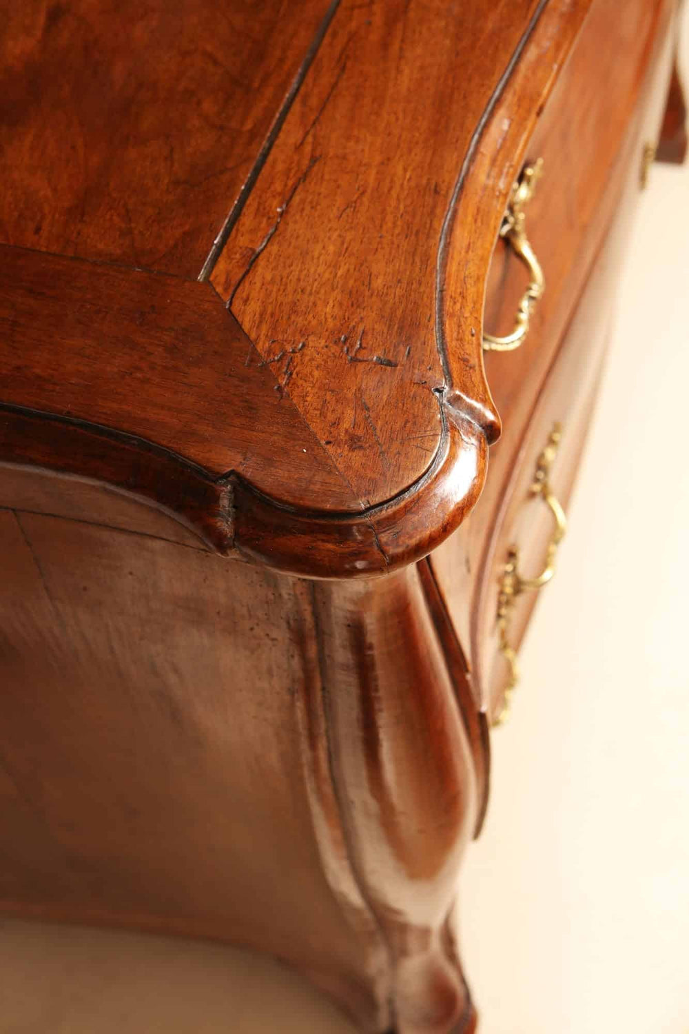 Close-up of Louis XV walnut veneered commode with ornate drawer handles by Nwtiques