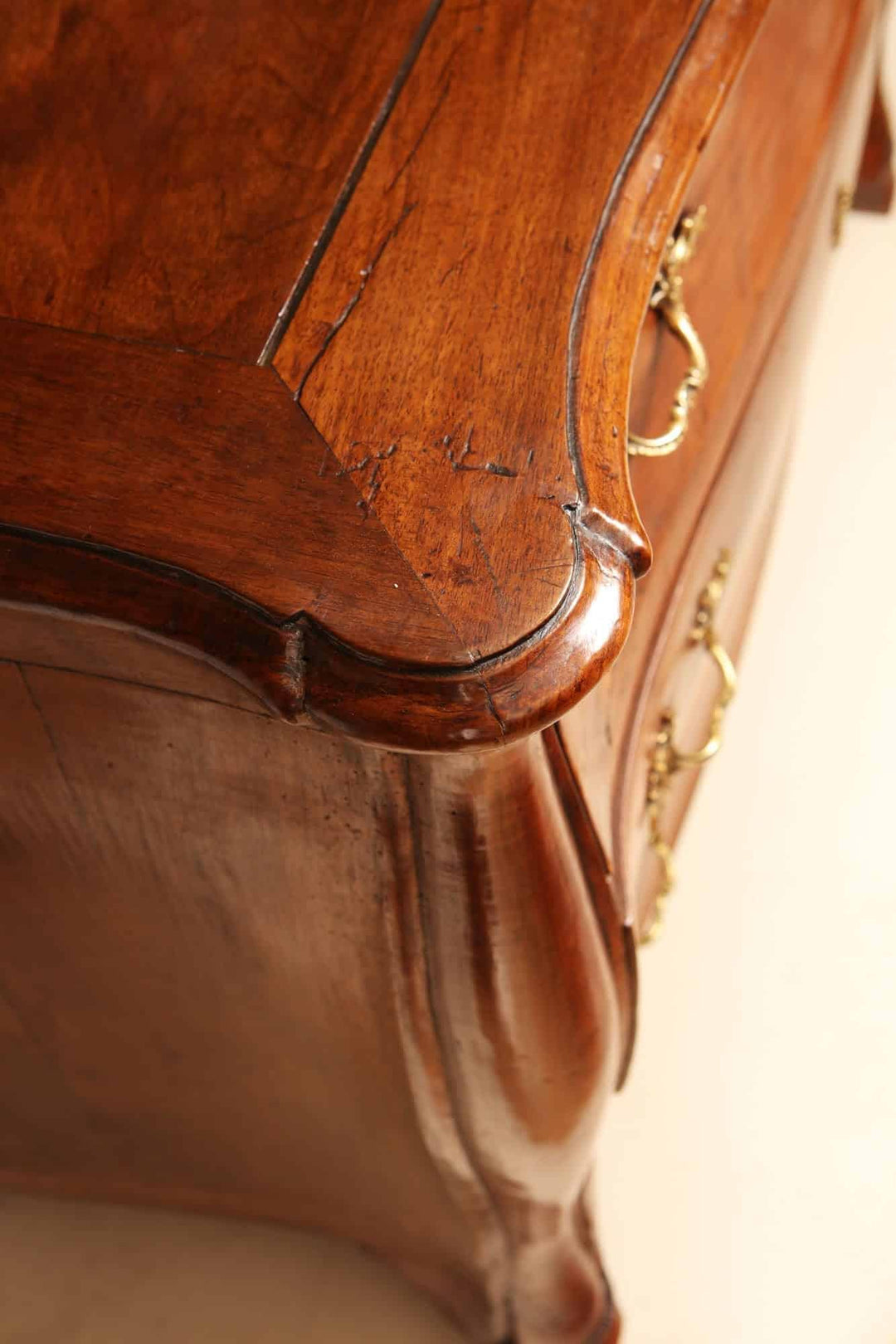 Close-up of Louis XV walnut veneered commode with ornate drawer handles by Nwtiques