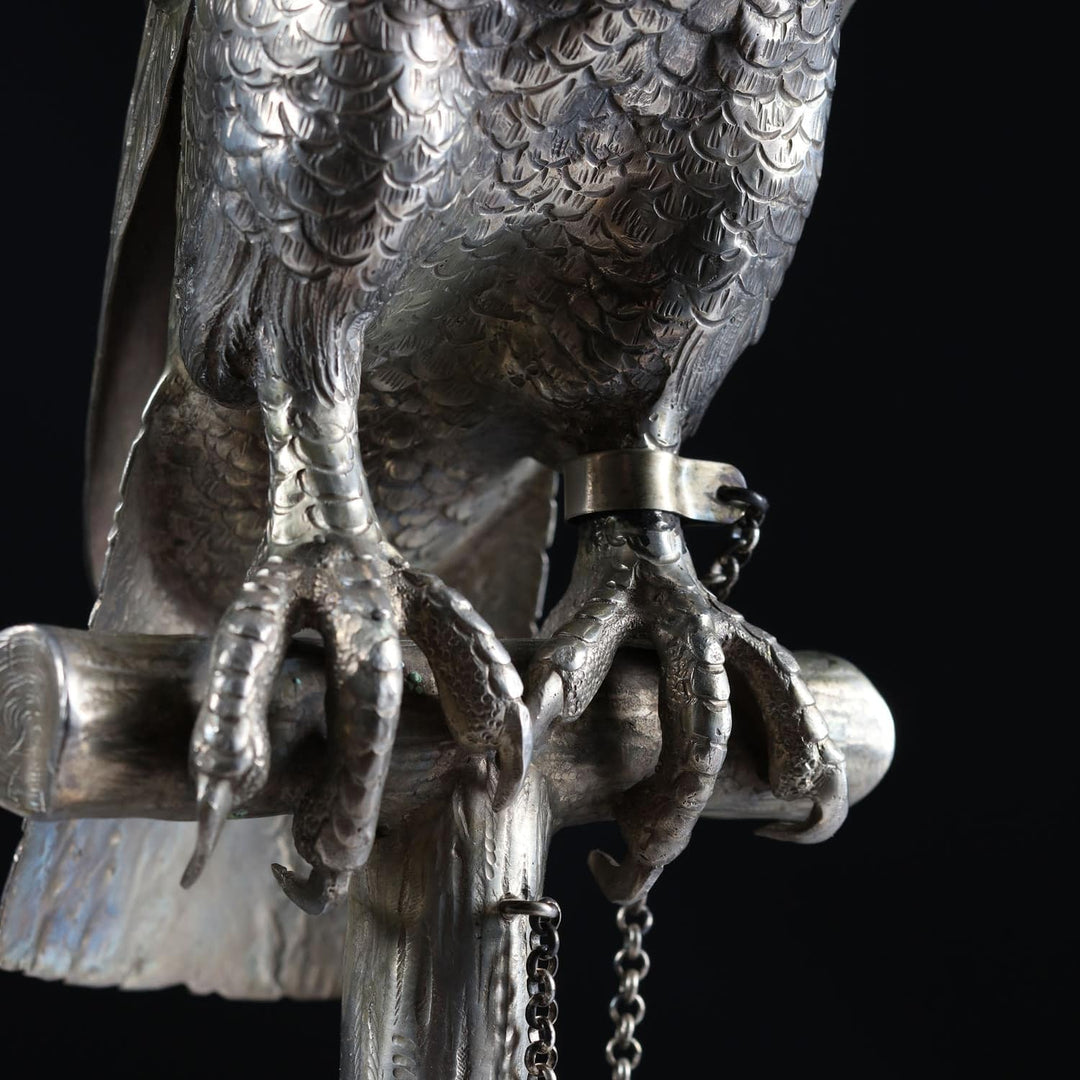 Detailed close-up of solid silver hawk sculpture claws perched on wooden post from Collection CK20