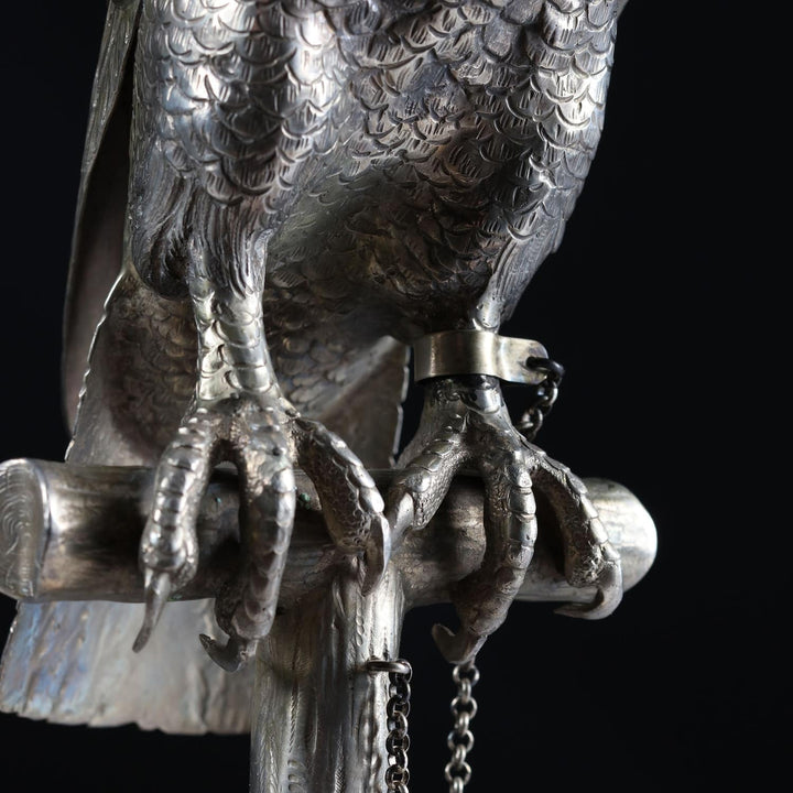 Detailed close-up of solid silver hawk sculpture claws perched on wooden post from Collection CK20