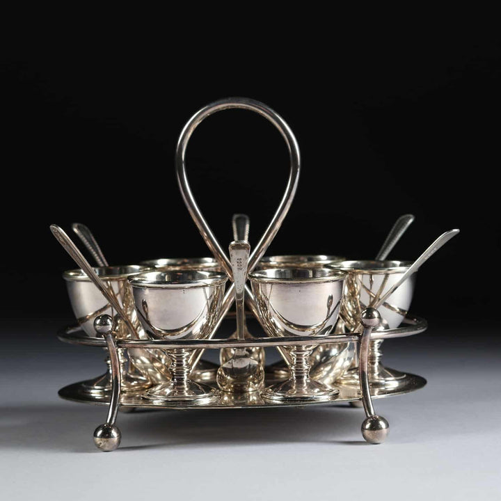 Hukin & Heath silver plated six egg cruet with spoons and twisted handle from Nwtiques
