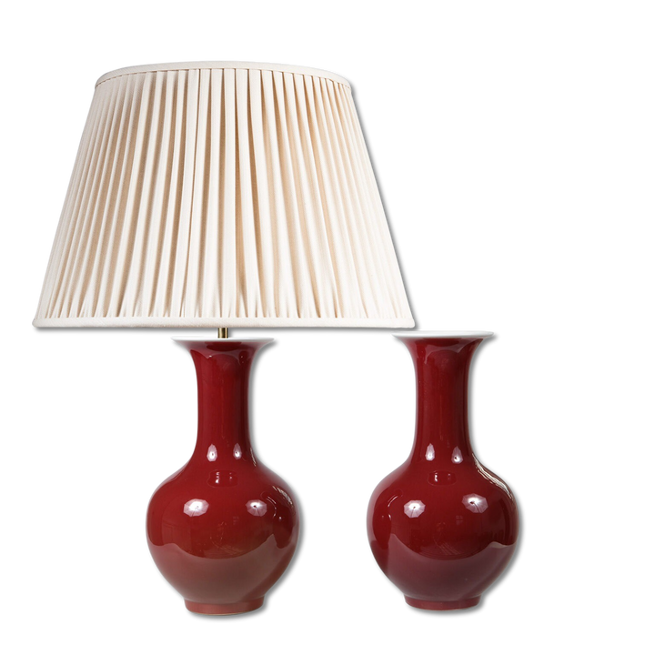 Pair of Sang de Boeuf Bottle Vases as Table Lamps with deep red glaze and one vase fitted with a cream pleated lampshade.