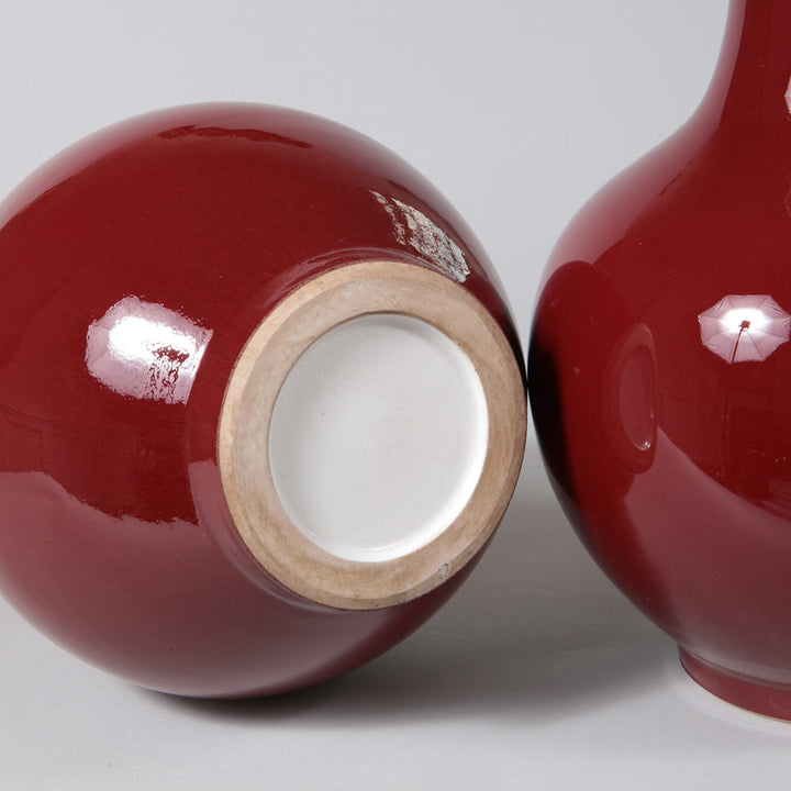 Pair of Sang de Boeuf Bottle Vases as Table Lamps showing glossy deep red finish and round ceramic bases.