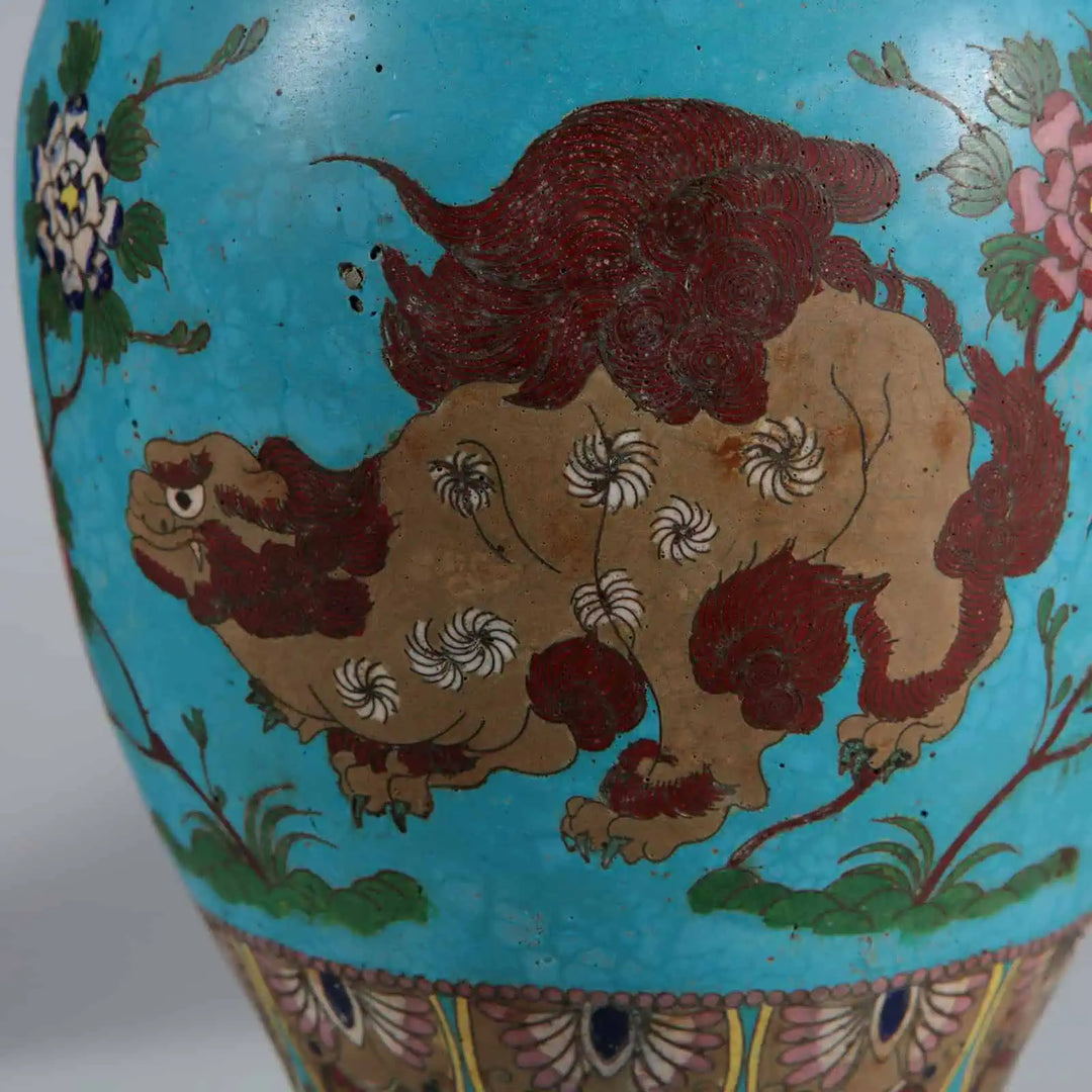 Pair of Chinese Cloisonné Lamps with detailed foo dogs in red and brown on blue background with floral motifs.