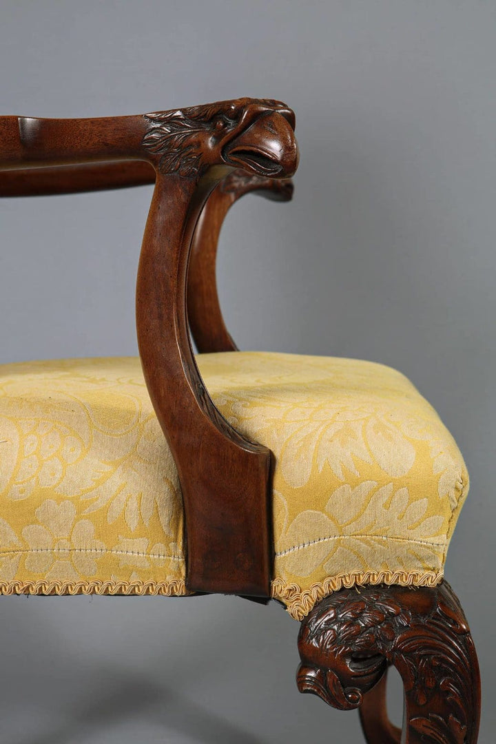Close-up of a George I style walnut armchair with carved eagle head arm and yellow silk damask seat by Collection CK20