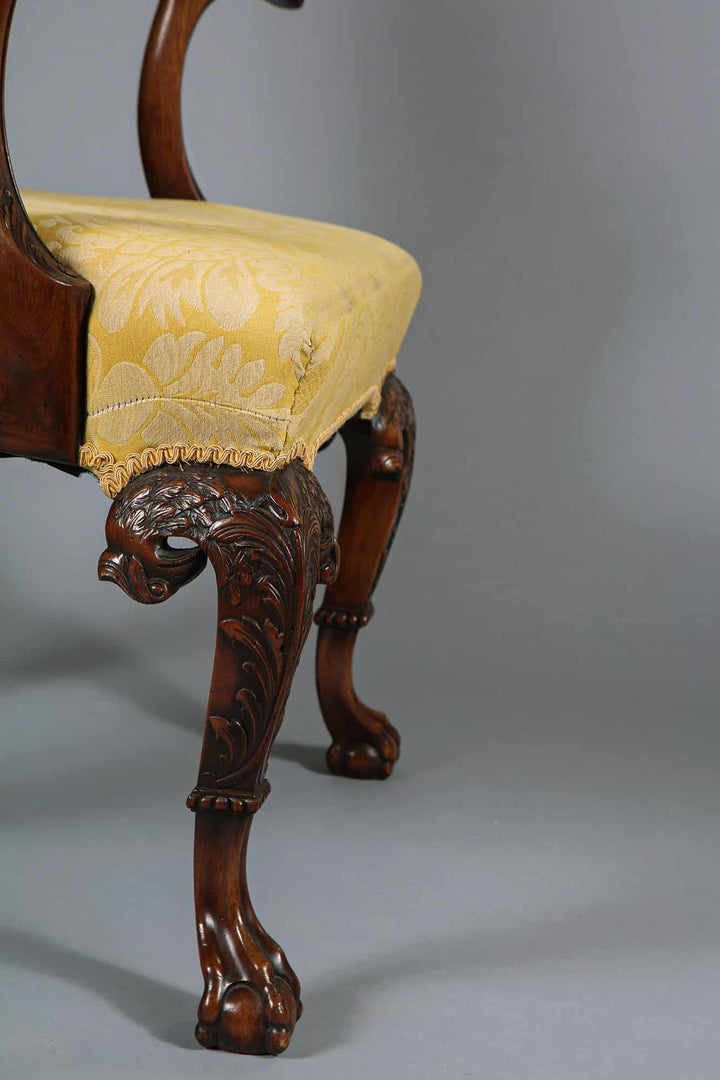 Close-up of George I style walnut armchair leg with eagle head carving and yellow silk damask seat by Collection CK20