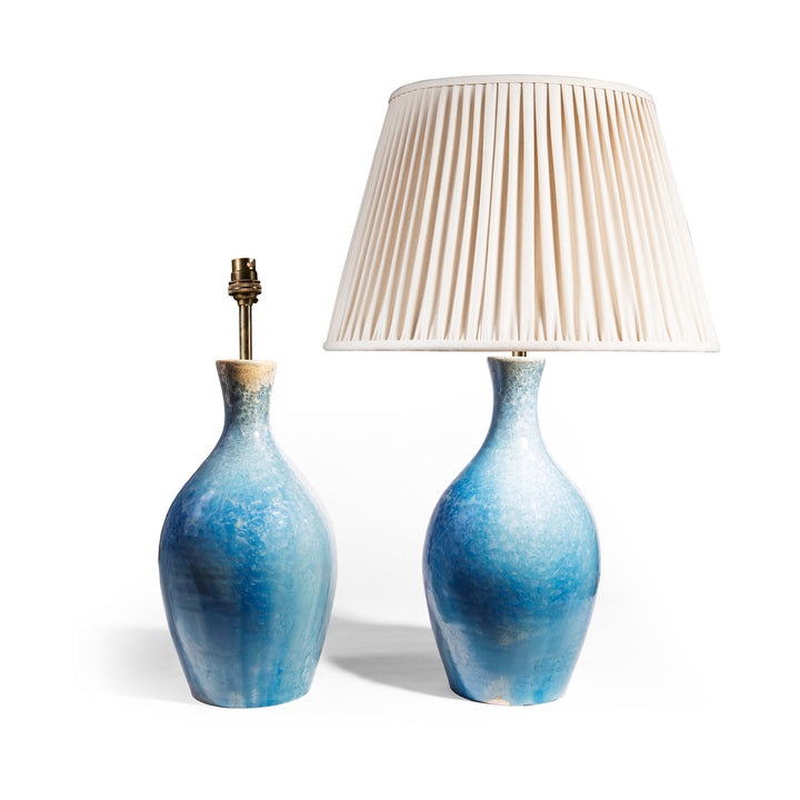 Pair of blue crystalline glaze ceramic table lamps by Nwtiques with one lamp featuring a pleated ivory shade