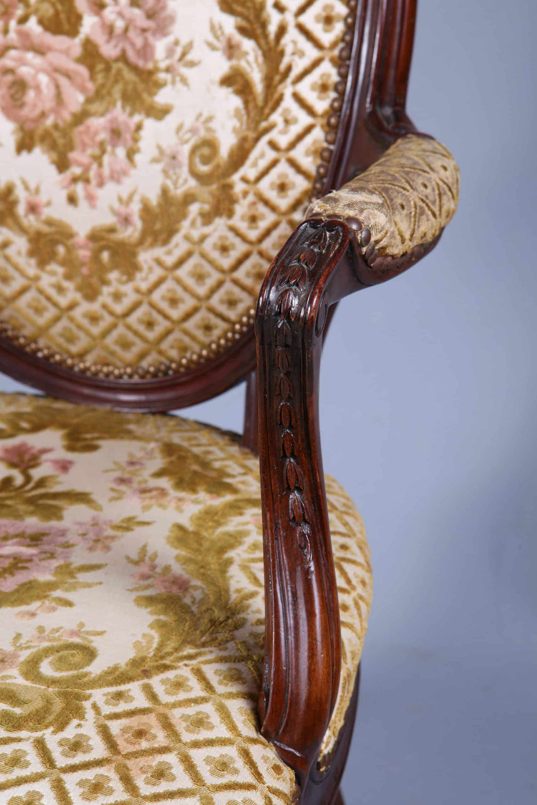 Close-up of carved mahogany armrest and floral upholstery on George III armchair by Nwtiques