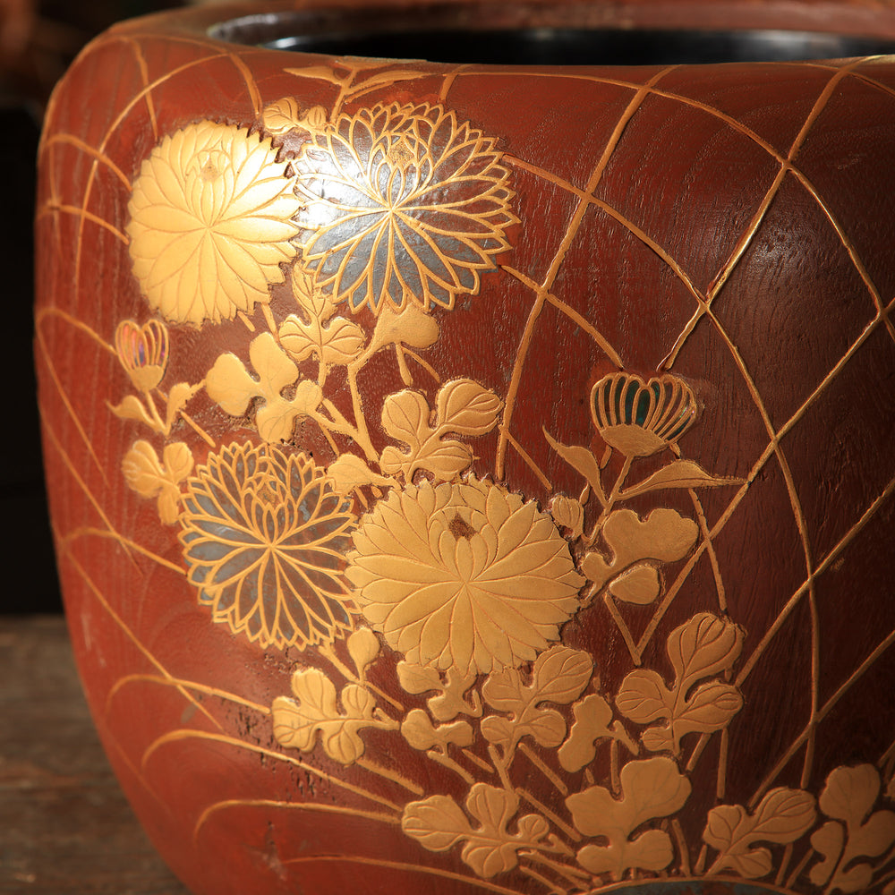 Decorative vase with gold floral patterns on a brown background