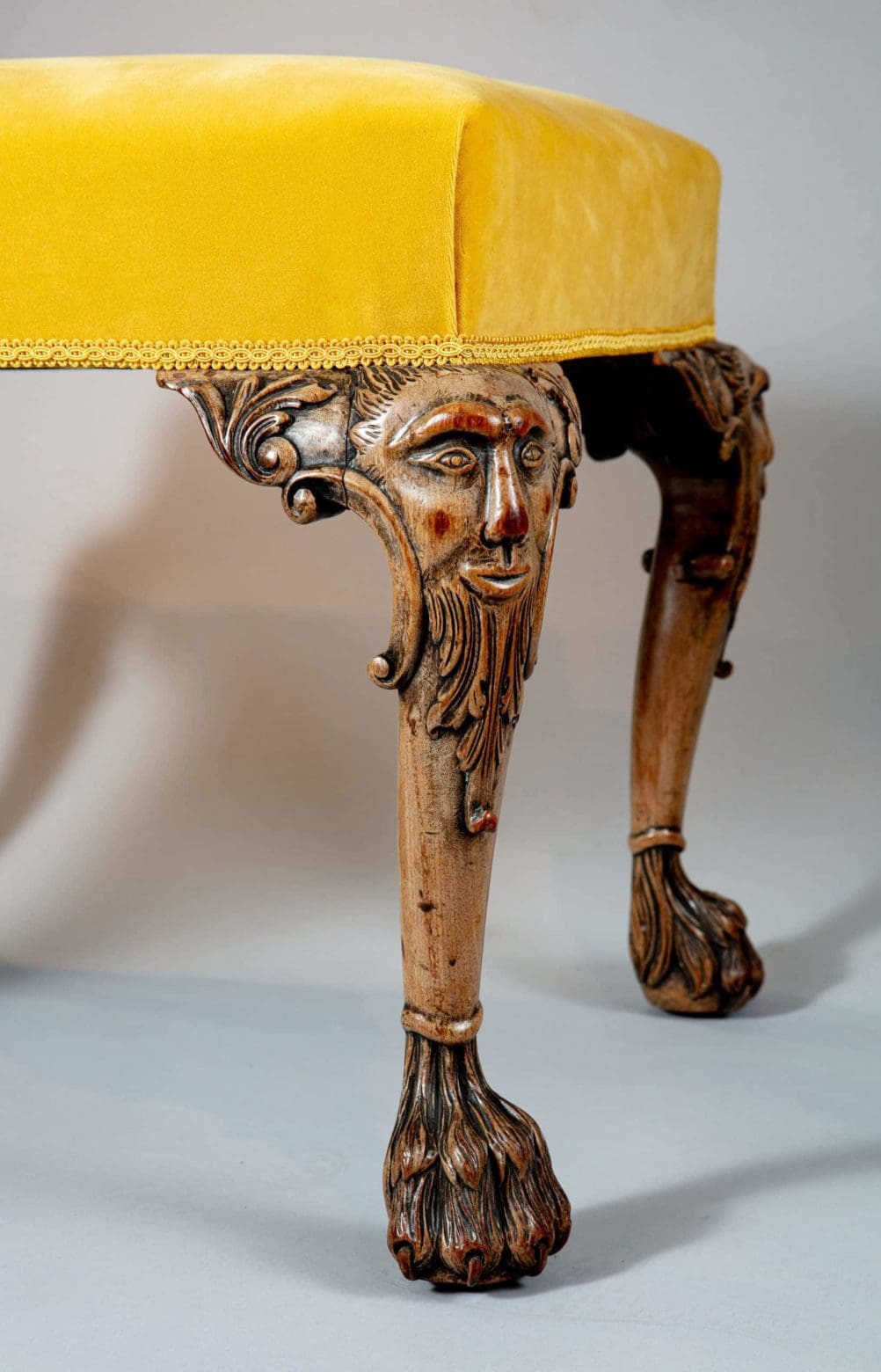 Carved George II style stool leg with mythical face and paw foot, yellow velvet seat, Collection CK20.