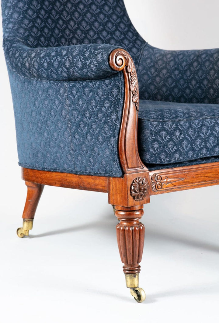 Close-up of Regency lyre form rosewood chair leg and carved armrest upholstered in blue fabric from Collection CK20