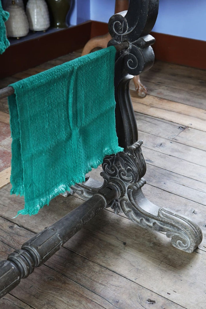 Close-up of ornate ebonised double saddle rack stand with carved scroll feet by Collection EE10 on wooden floor