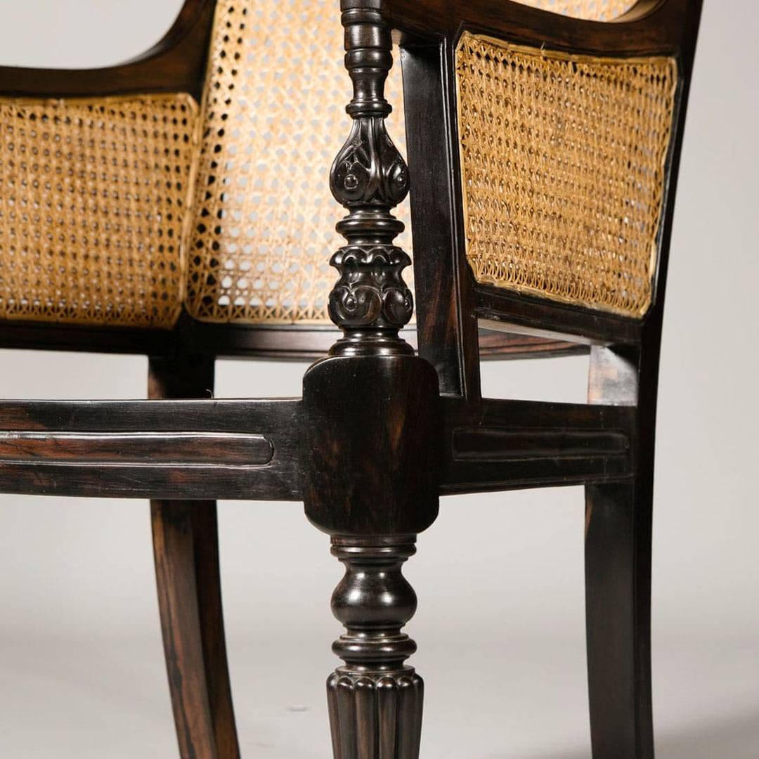 Close-up of intricately carved ebony caned library chair leg from Collection EE30 showcasing Regency craftsmanship detail.