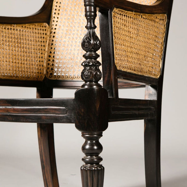 Close-up of intricately carved ebony caned library chair leg from Collection EE30 showcasing Regency craftsmanship detail.