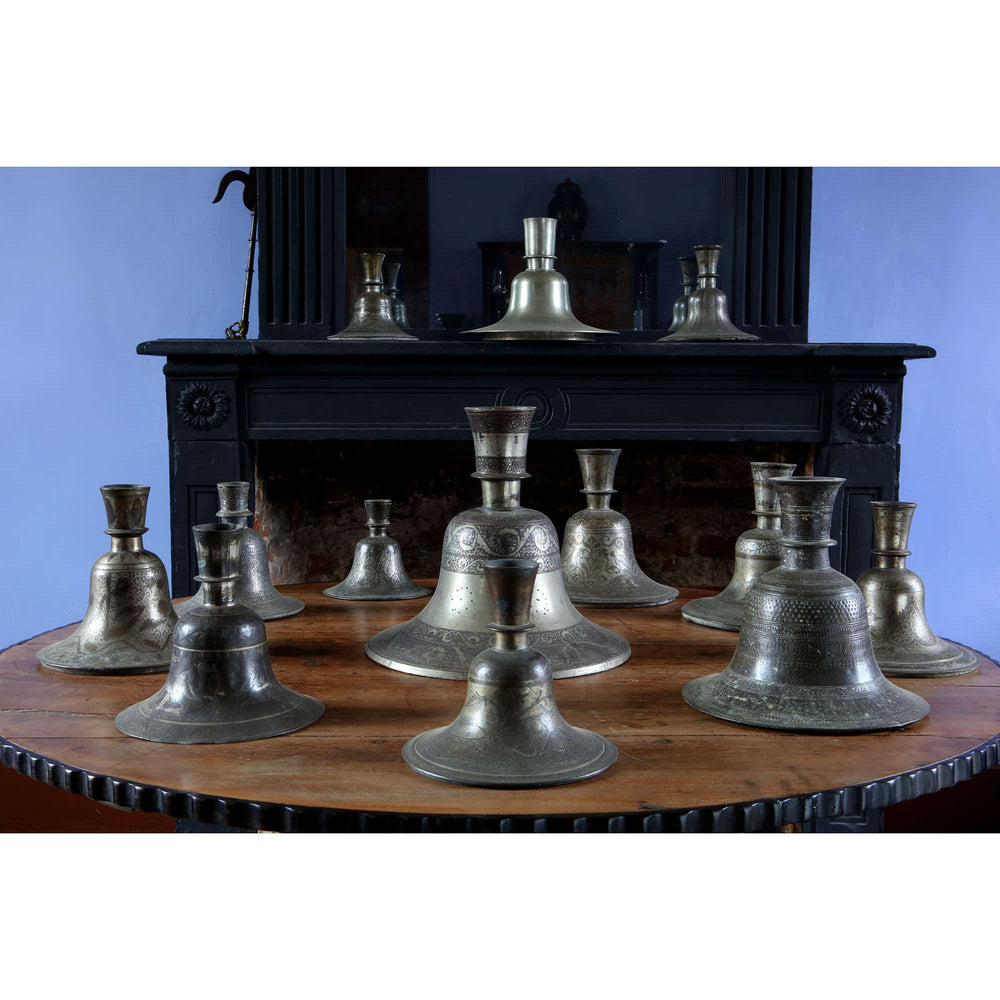 Collection EE20 of 13 engraved Indian metal hookah bases from the 19th and 20th centuries on a wooden table