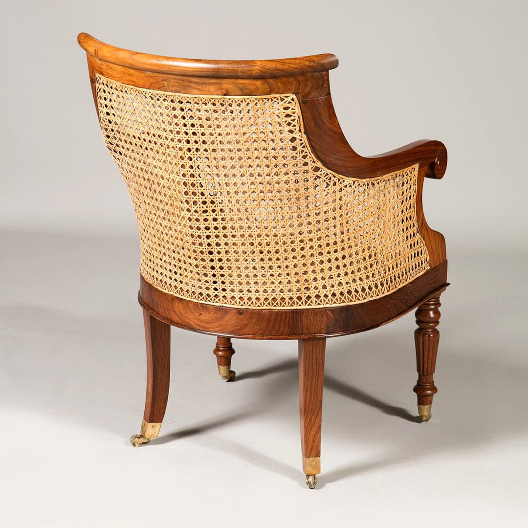 Regency style caned library chair with curved wood frame and brass castors by Collection EE30, elegant and handcrafted