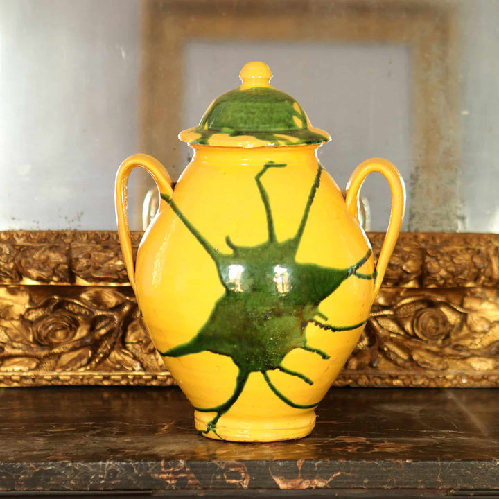 Canary yellow vase with green splash design and lid from Collection EE20 displayed on wooden surface