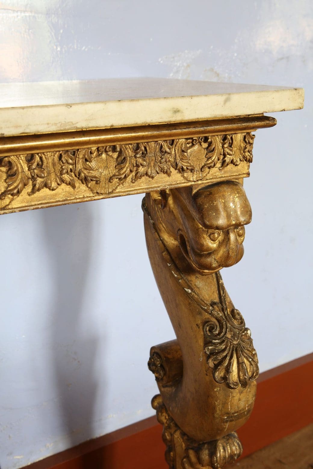 Regency Giltwood Console Table After the Antique with detailed giltwood carvings and white marble top.
