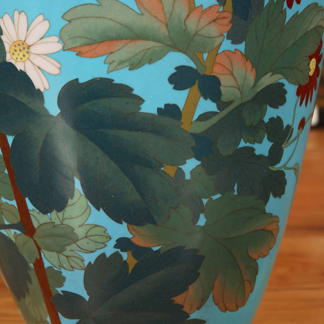Close-up of a superb Japanese Cloisonne enamel vase with detailed floral design on light blue background by Nwtiques