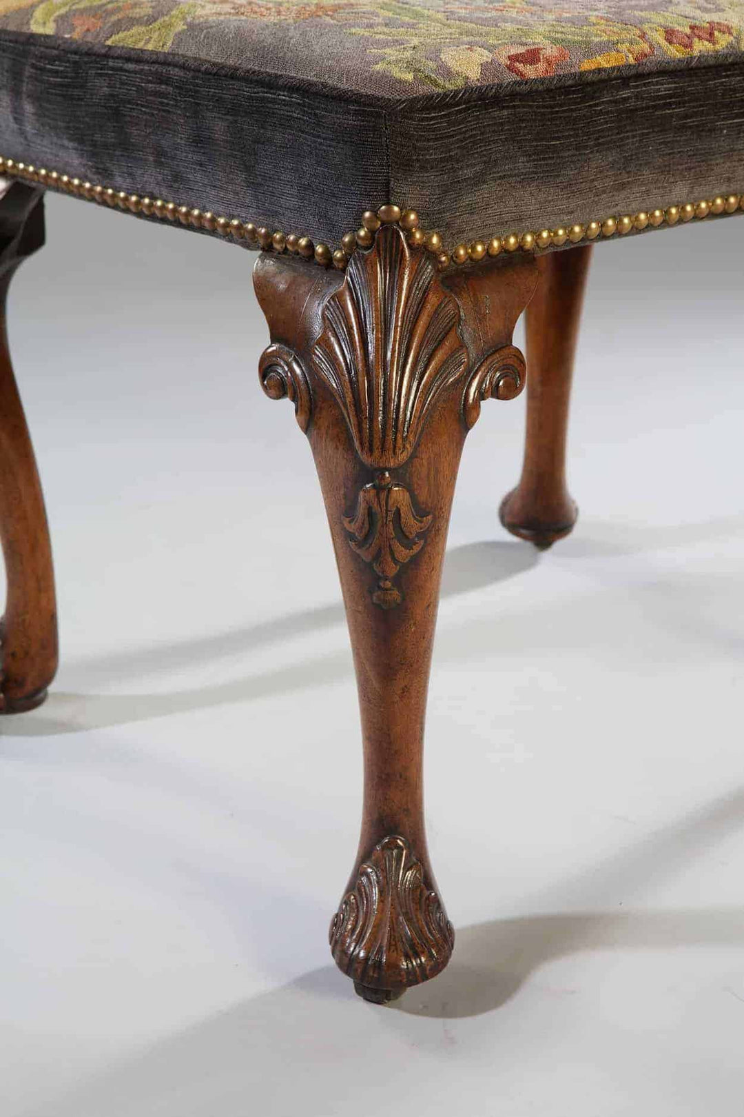Close-up of carved walnut cabriole leg and petit point upholstery on early 18th century stool from Collection CK20