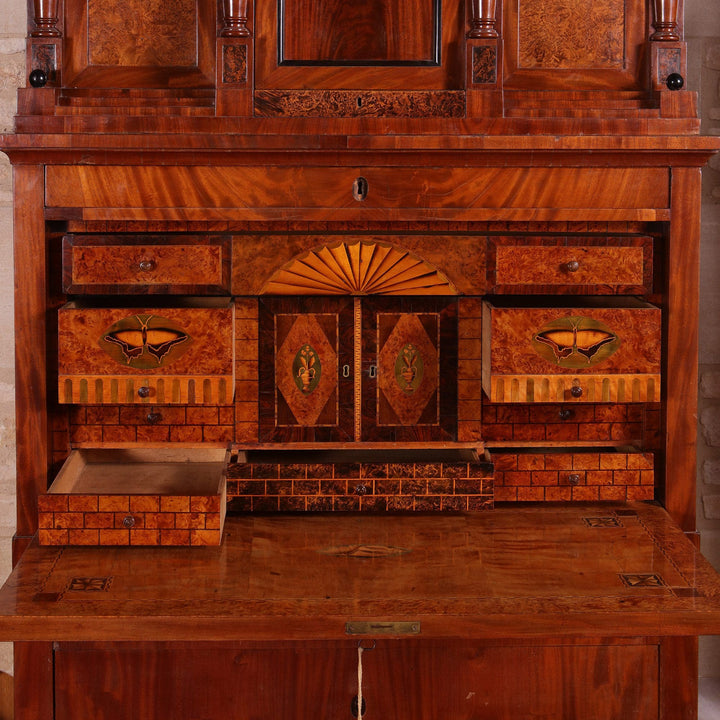 Biedermeier Secretaire abattant with flame mahogany veneers, fitted interior, hidden compartments, and three long drawers, circa 1815.