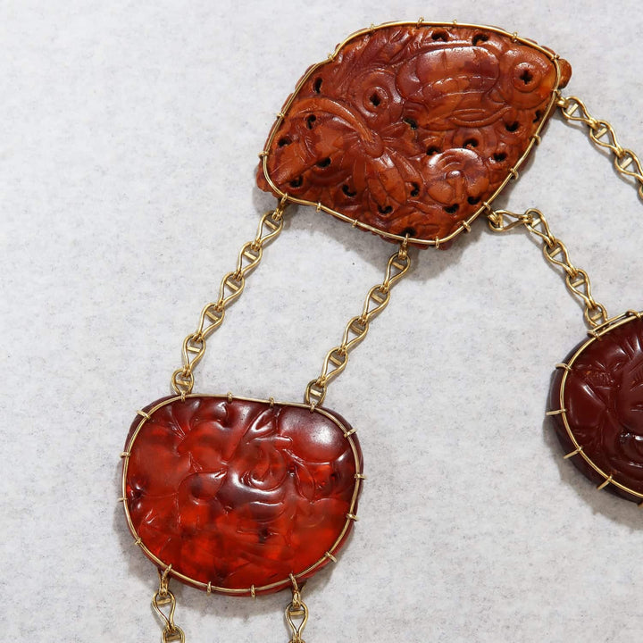 Close-up of Chinese carved amber pendant necklace with gold mounts by Nwtiques