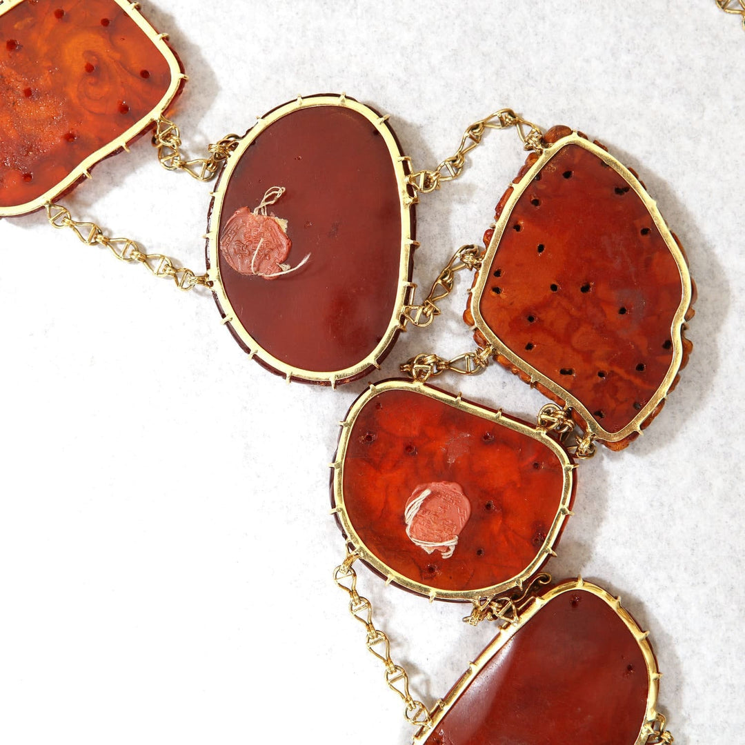 Chinese carved amber gold mounted necklace from Nwtiques with warm golden hues and intricate details